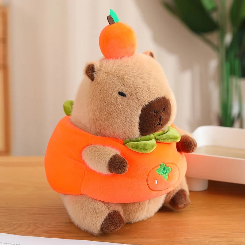 Kawaii plush toy bear in a pumpkin costume on a wooden surface