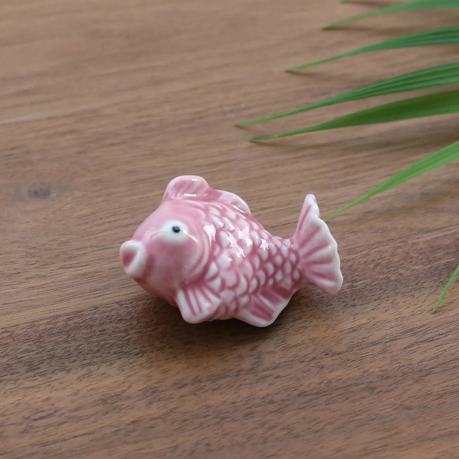 A pink fish kawaii chopstick holders on a table
