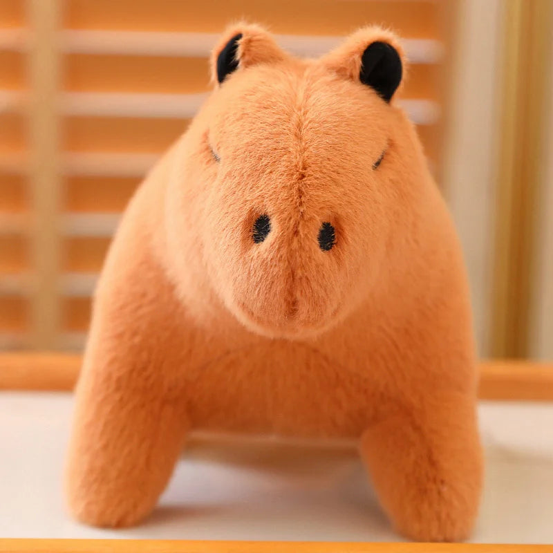 Kawaii plush toy hippo on a white surface with an orange background