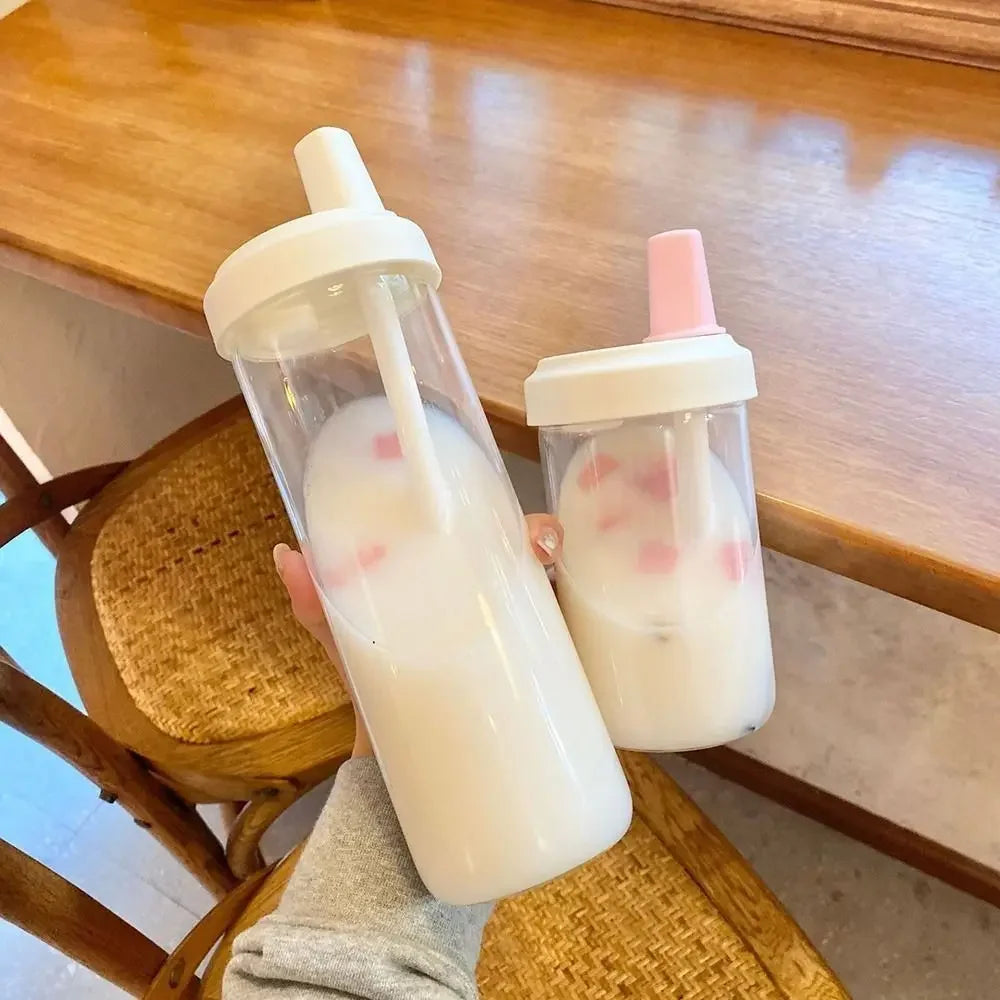 Two kawaii cups with animal designs on a wooden table.