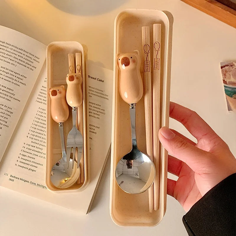 Someone holding up a brown case with kawaii utensils inside it