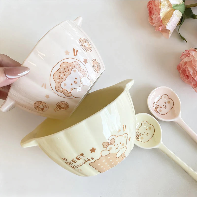 Two pumpkin shaped kawaii bowl sitting on a table next to spoons