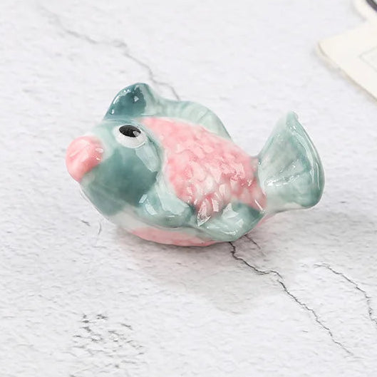 Small ceramic fish kawaii chopstick holders on a light surface with text indicating dimensions.