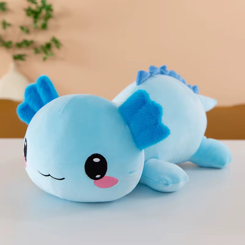 Blue plush toy with a happy expression on a light surface.