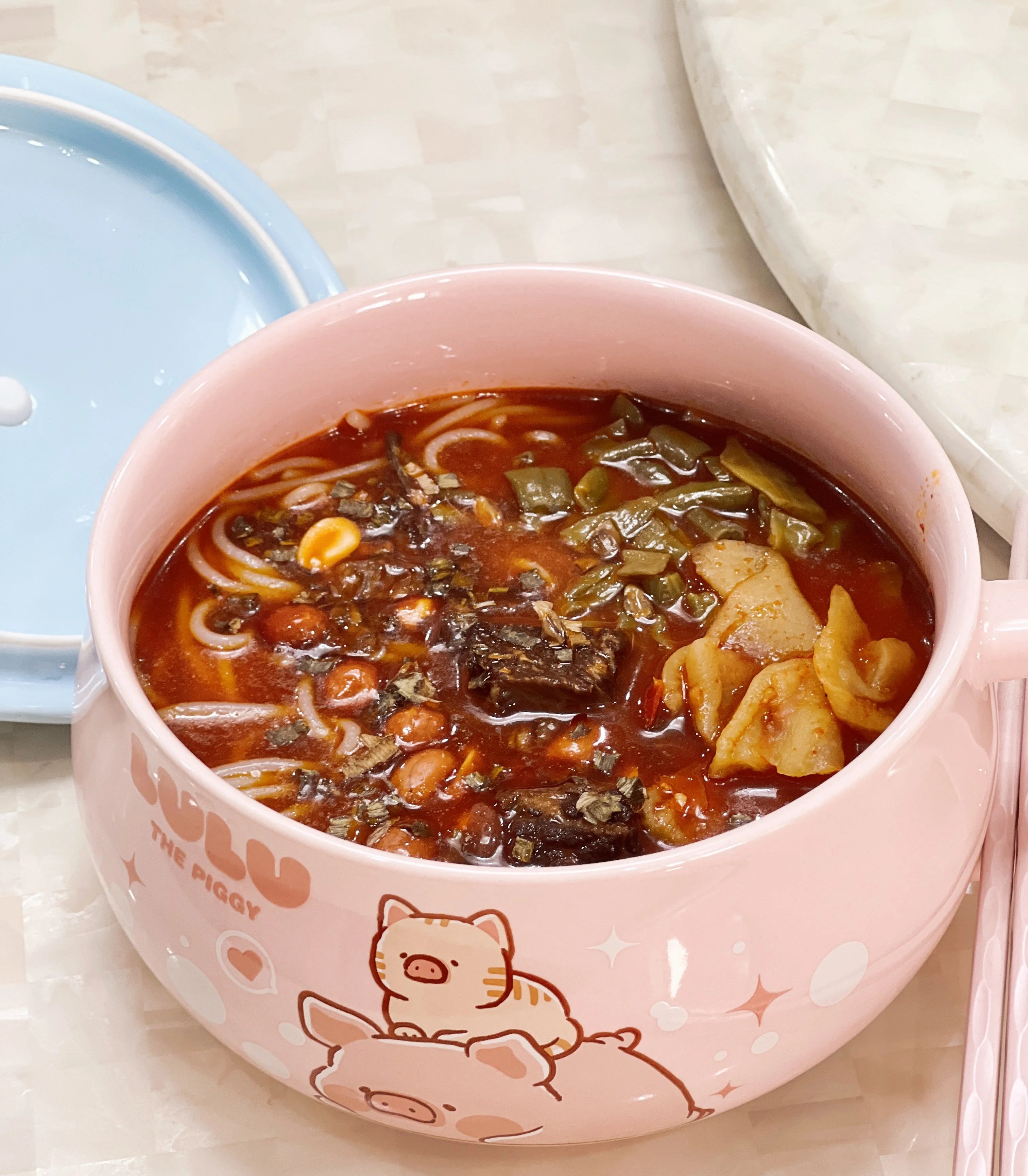 A pink, piggy themed kawaii ramen bowl with stew in it