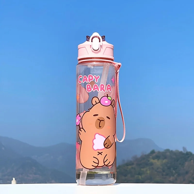 Clear kawaii water bottle with cartoon bear design and 'Capybara' text against a blue sky and mountain background