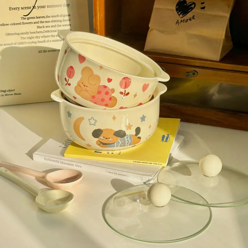 Set of children's kawaii ramen bowls with cartoon designs on a table with books and a glass dish.