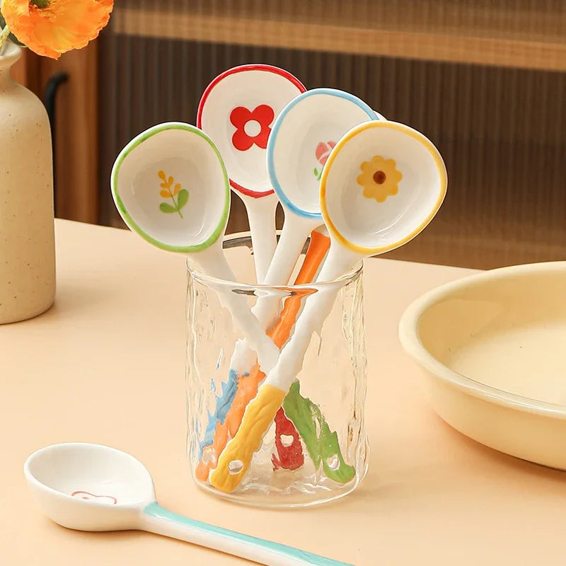 Four white and colored kawaii spoons in a glass