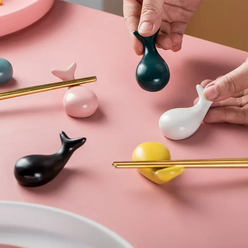 Five kawaii chopstick holders sitting on a pink table