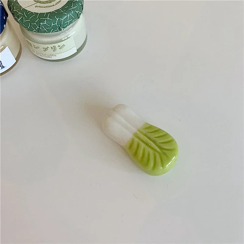 Small green and white kawaii chopstick holder on a light gray surface