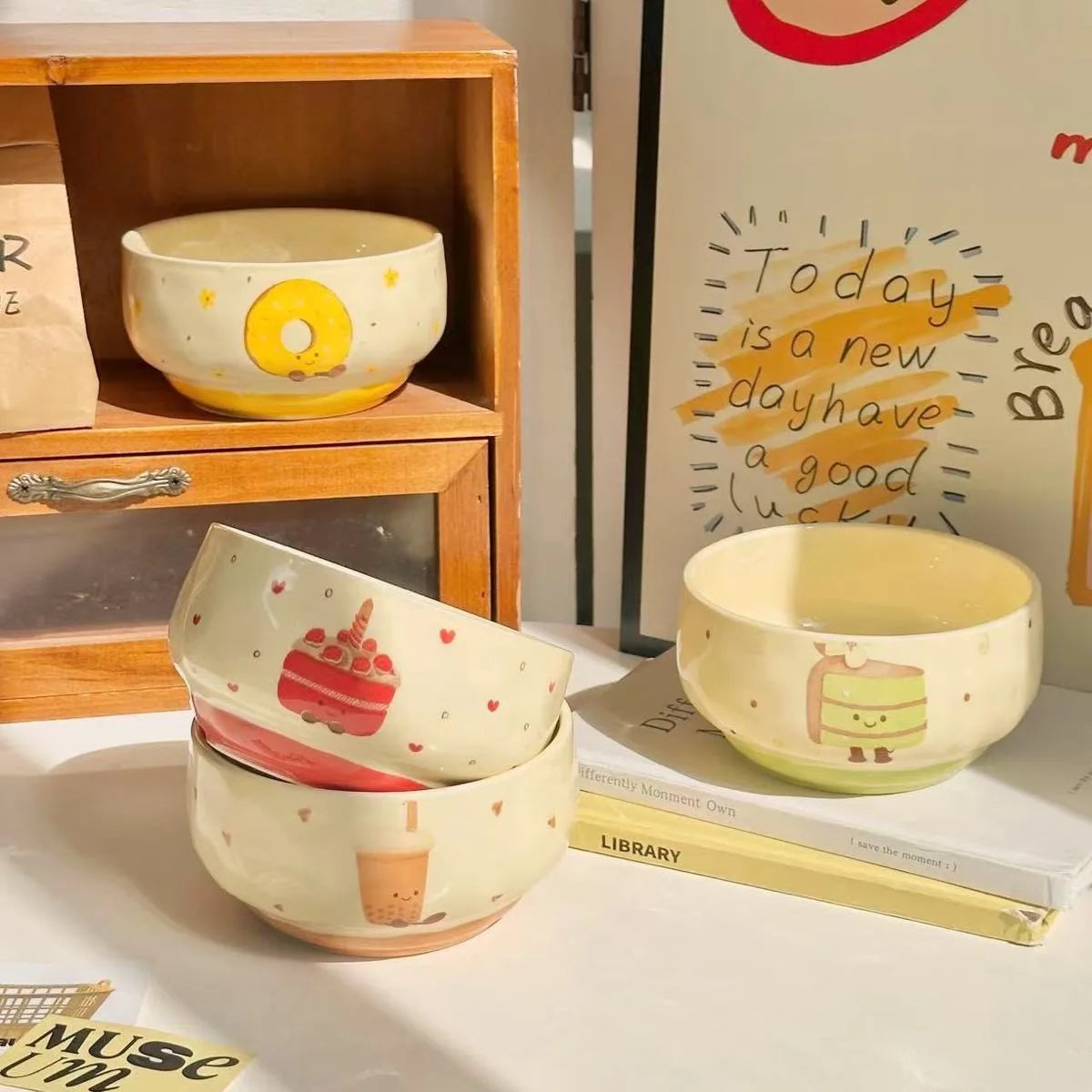 Set of ceramic kawaii bowls with cartoon designs on a shelf.