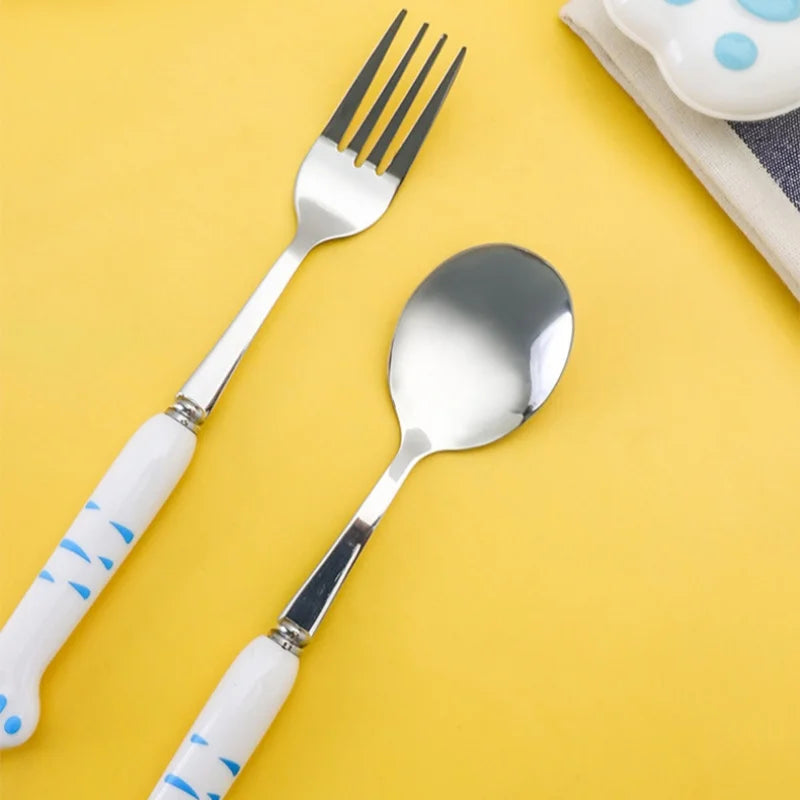 Kawaii utensils with white handles featuring blue cat designs on a yellow background