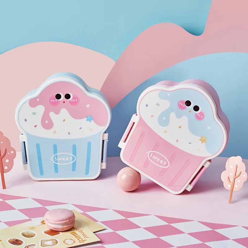 Two cute, cartoon-style kawaii lunch boxes on a checkered tablecloth with a pink and blue background.