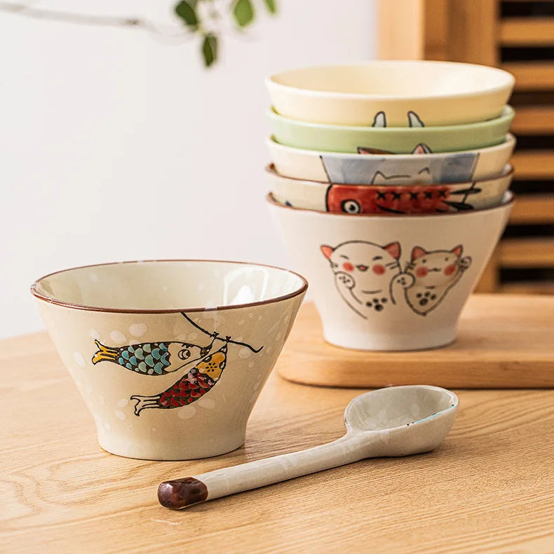 Set of ceramic kawaii ramen bowls with animal illustrations on a wooden surface