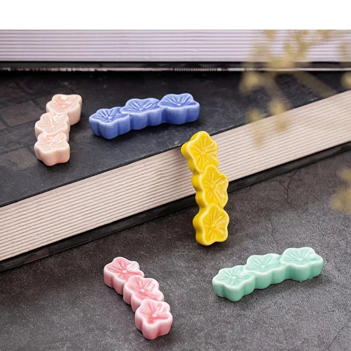 Colorful cookie-shaped kawaii chopstick holders on a book with a blurred background
