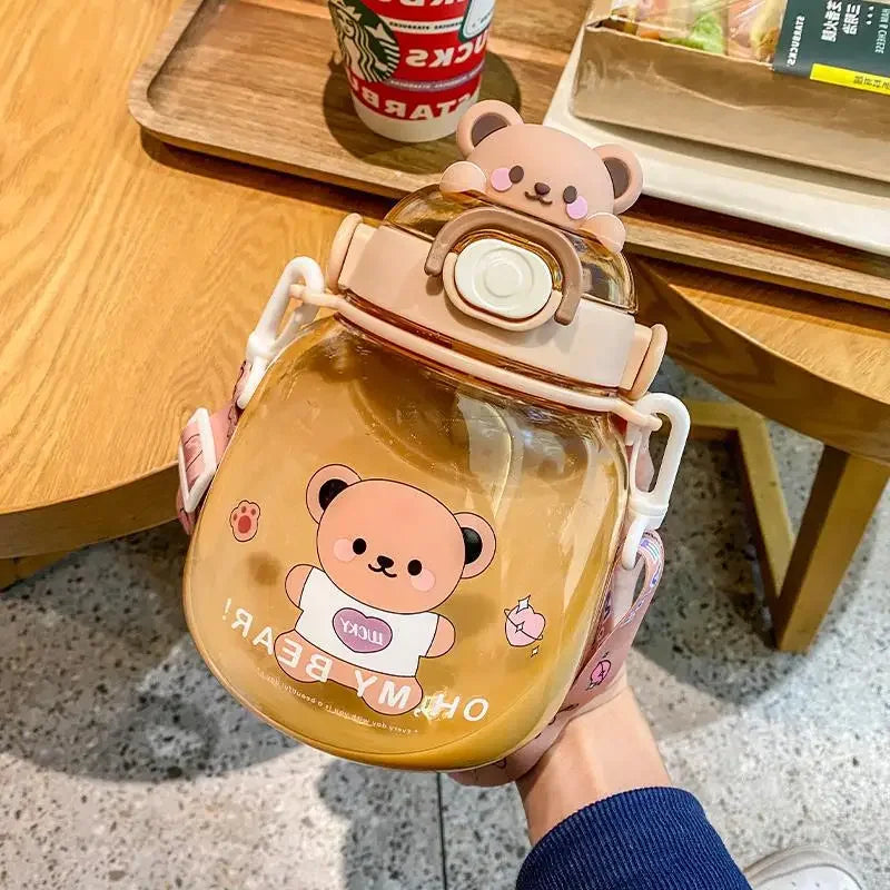 Clear kawaii bottle with bear design held by a hand on a wooden table.