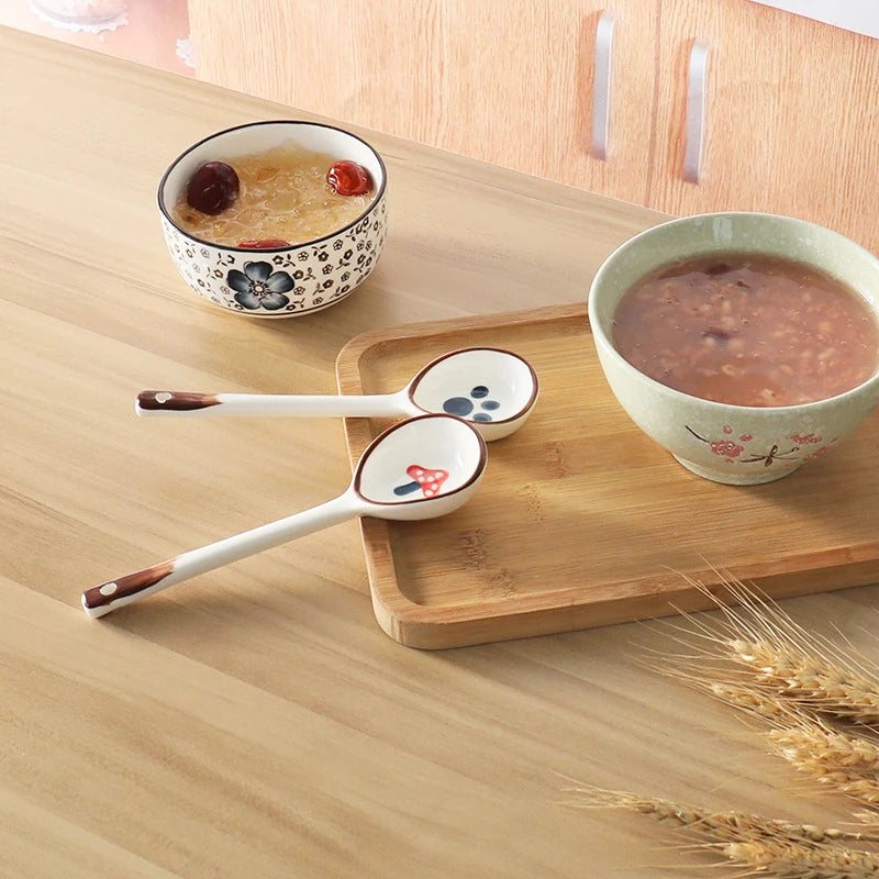Two white ceramic kawaii spoons on a tray
