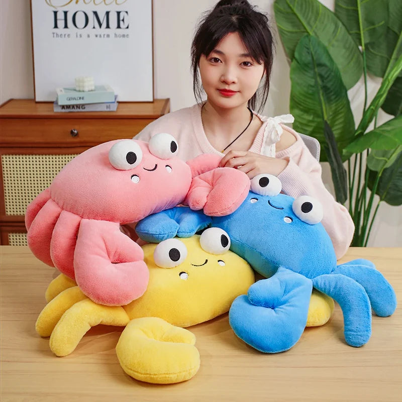 Woman holding colorful kawaii plush crab toys on a wooden table.