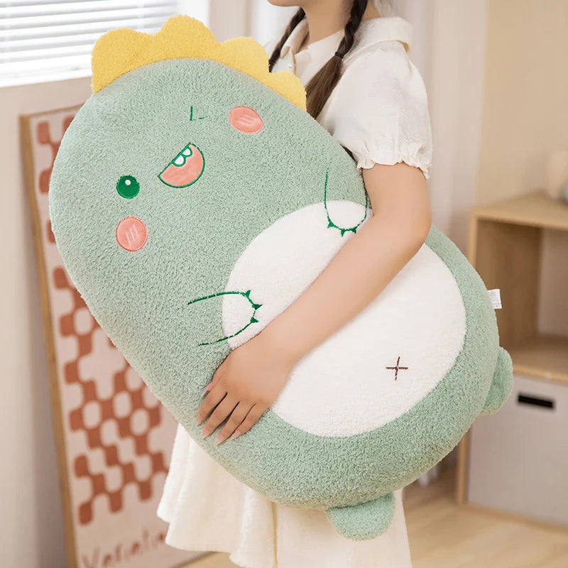 Person holding a large green dinosaur-shaped kawaii pillow in a room.