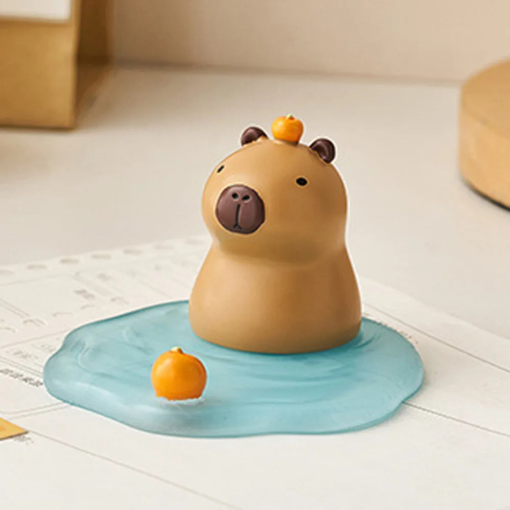 Kawaii phone holder of a bath toy with a small orange ball on a light blue circular mat.