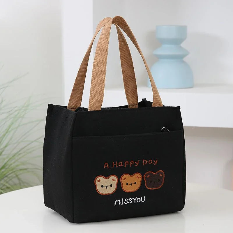 Black kawaii tote bag with bear illustrations and text on a white surface