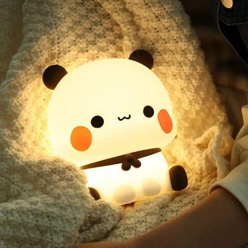 Cute panda-shaped kawaii night light held by a person on a soft surface