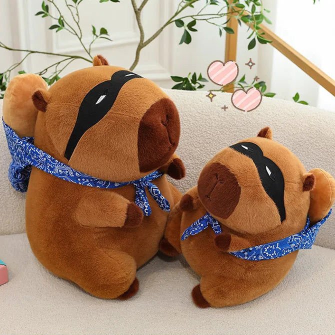 Two brown kawaii plush dogs with blue scarves on a light-colored couch.