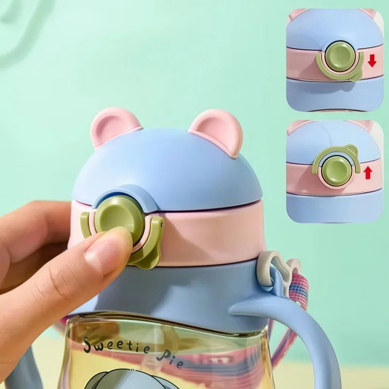Colorful kawaii water bottle with bear-like design held by a hand against a light green background
