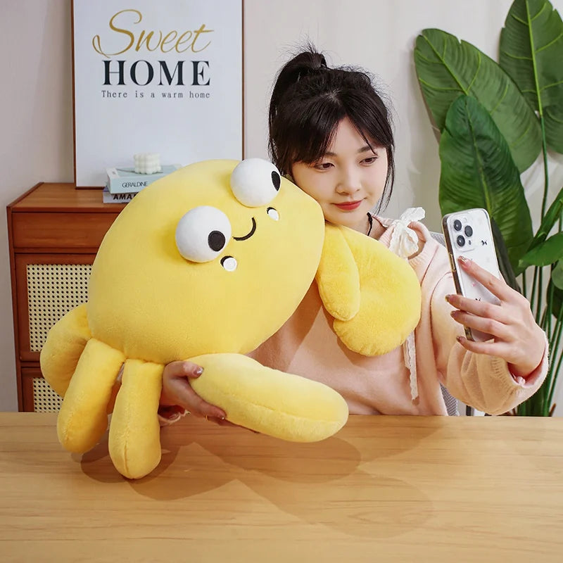 Person holding a kawaii plush crab toy and taking a selfie in a room with decor elements.