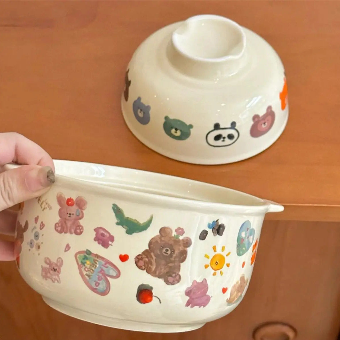 White ceramic kawaii bowl with colorful animal illustrations on a wooden surface