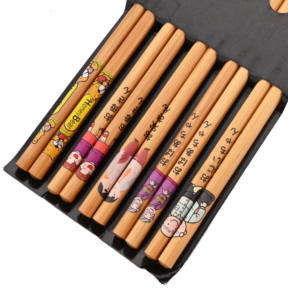 Set of wooden kawaii chopsticks with cartoon designs in a black holder