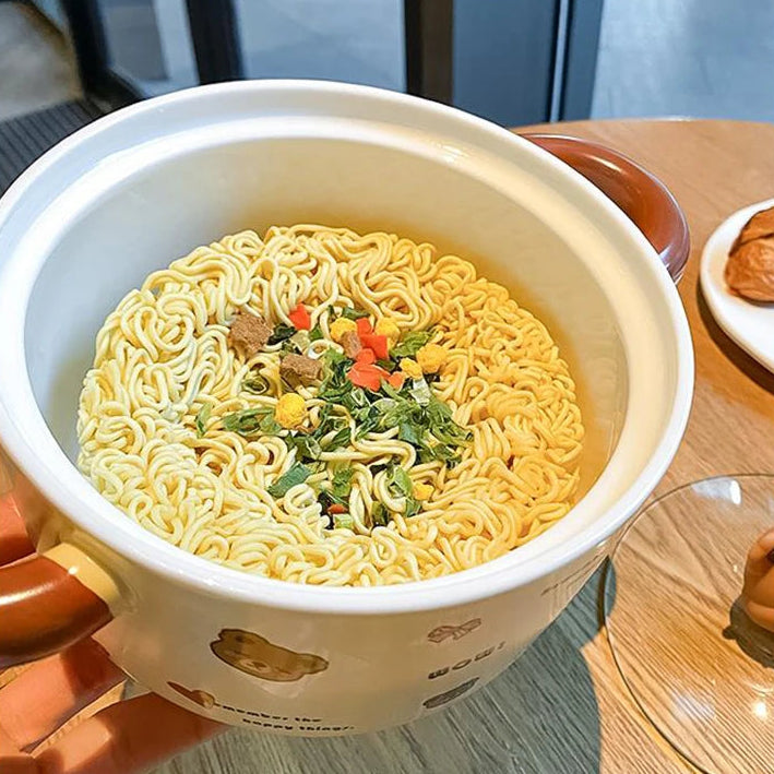 A close up of noodles inside a bear themed kawaii ramen bowl