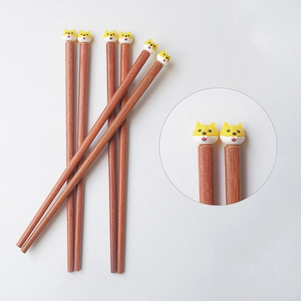 Set of four wooden kawaii chopsticks with cat-shaped erasers on a white background