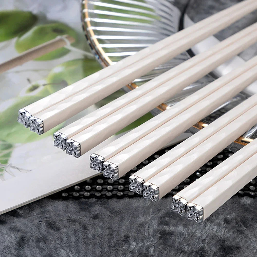 White kawaii chopsticks with decorative ends on a textured surface