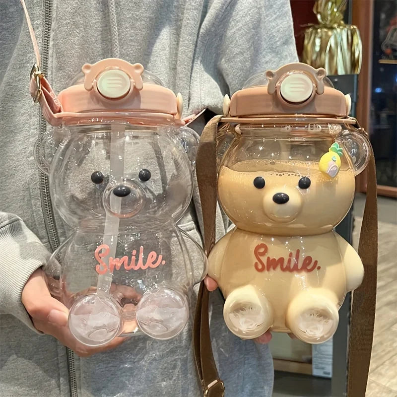 Two bear-shaped kawaii water bottles with 'Smile' text held by a person.