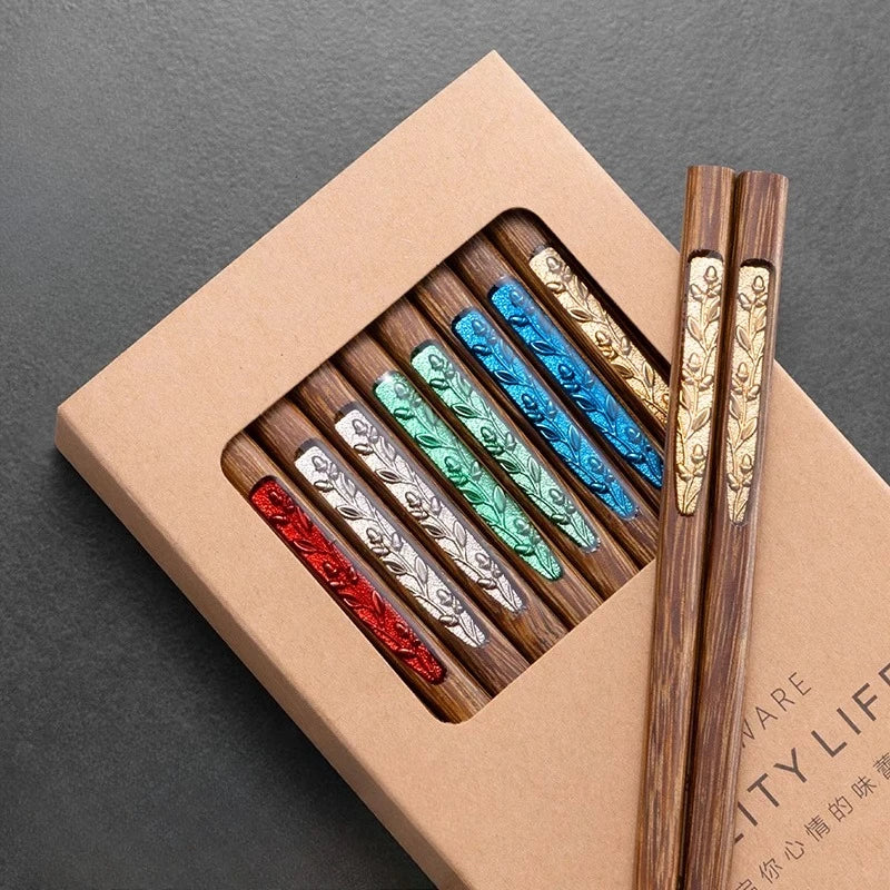 Set of wooden kawaii chopsticks with decorative handles in a box on a dark surface