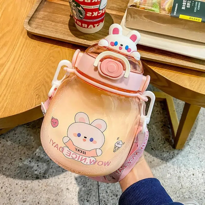 Cute cartoon-themed kawaii water bottle held by a person on a wooden table with a Starbucks cup in the background.