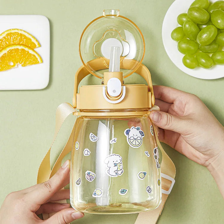 Clear kawaii water bottle with lemon design held by hands on a green background