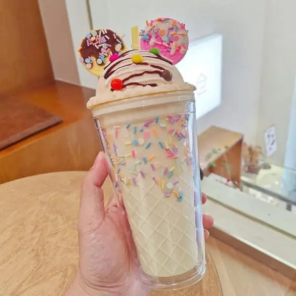 Hand holding a cone-shaped ice cream kawaii cup with colorful sprinkles and decorations.