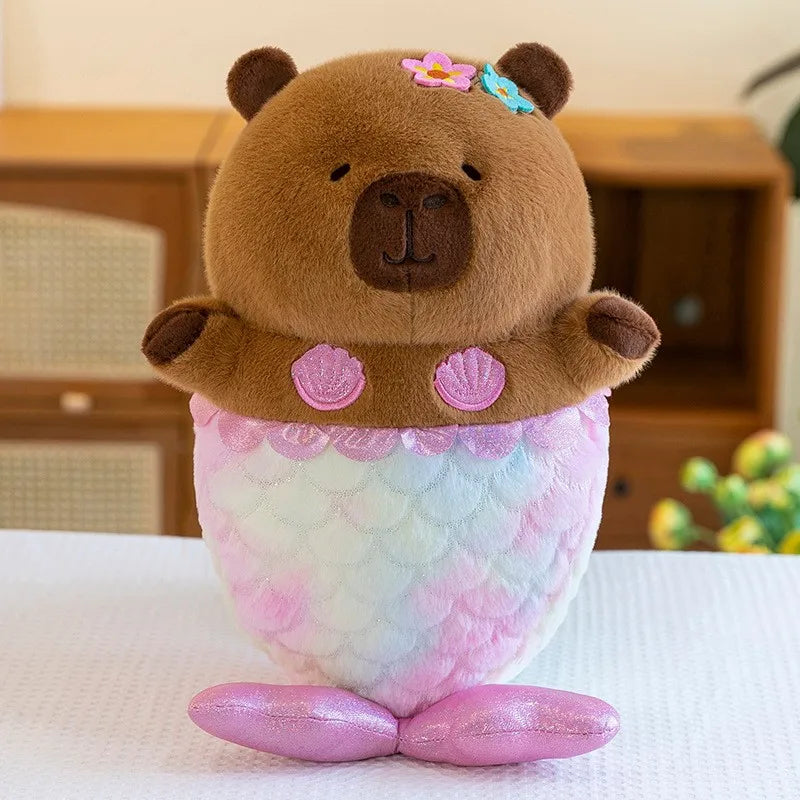 Capybara plush toy resembling a mermaid with bear ears on a white surface
