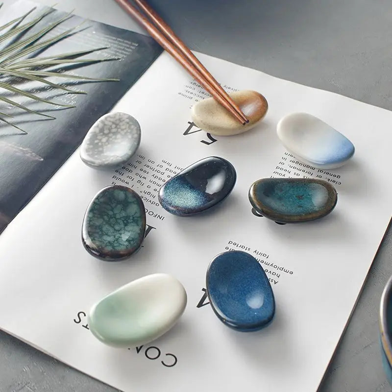 Set of ceramic kawaii chopstick holders with a copper rod on a magazine page