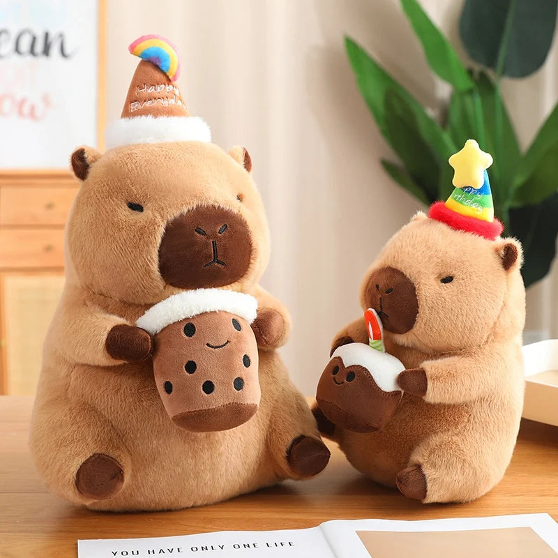 Two brown capybara plush toys with party hats on a wooden surface.