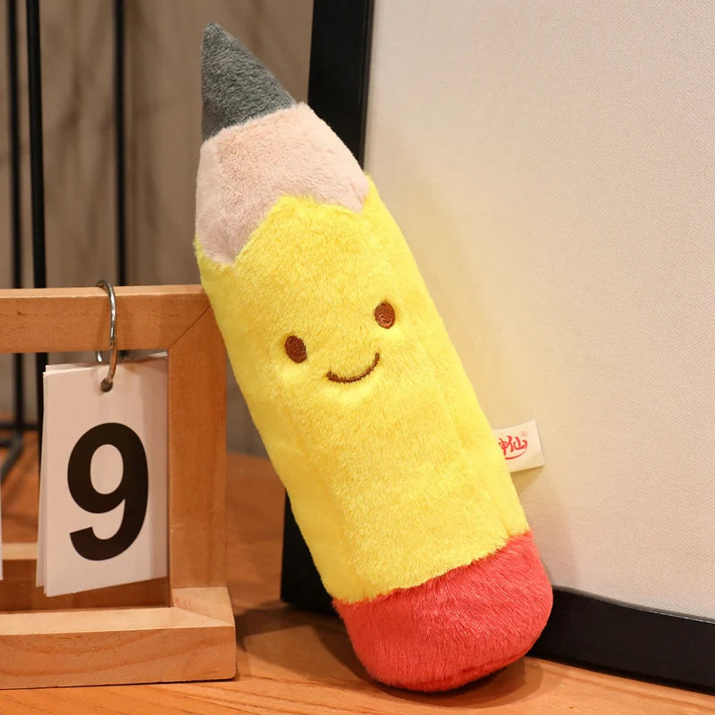 Kawaii plush toy shaped like a pencil with a smiley face on a wooden surface.