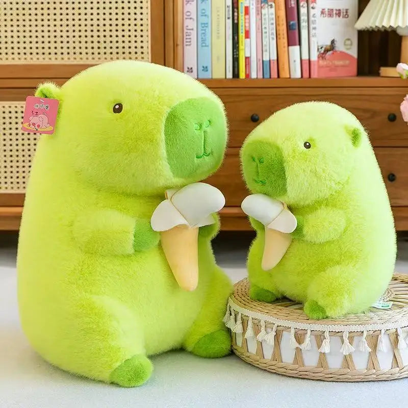 Two green kawaii plush toys resembling bears sitting on a light-colored surface with a wooden shelf and books in the background.