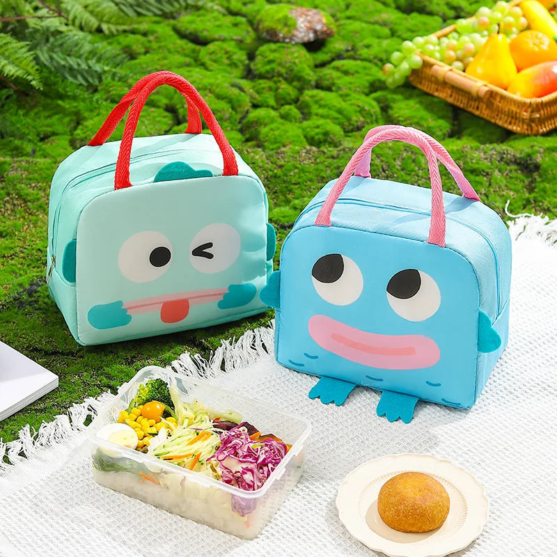 Two cartoon-style kawaii lunch bags on a picnic blanket with food items.