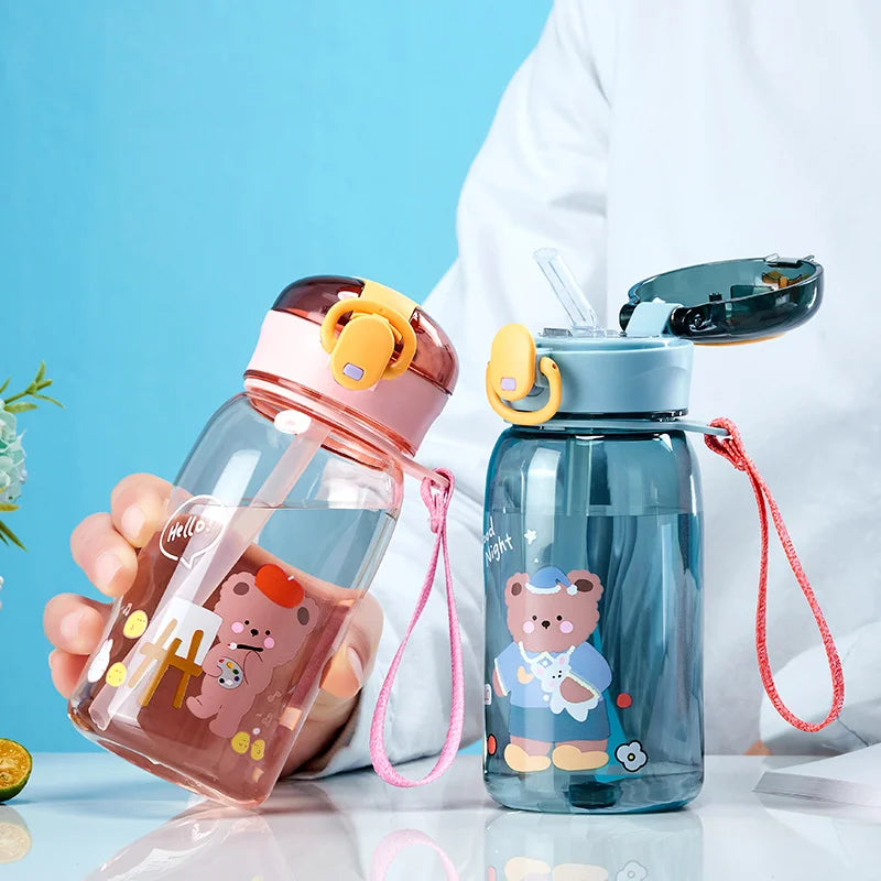 Two children's kawaii water bottles with cartoon designs on a blue background