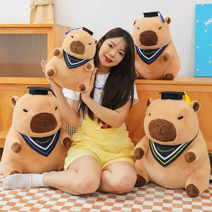 Woman sitting on a checkered floor with four large capybara kawaii plush toys.