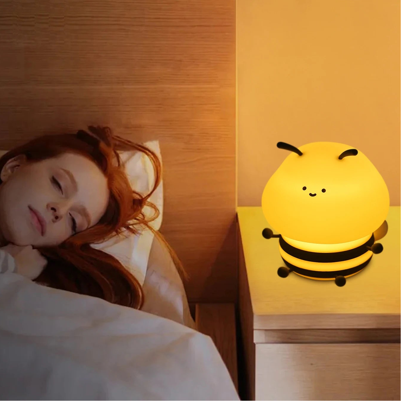 Woman lying in bed with a bee-shaped kawaii night light on a nightstand, emphasizing soft warm lighting.