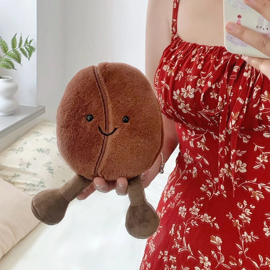 Person holding a kawaii plush toy shaped like a chestnut with a smiling face.