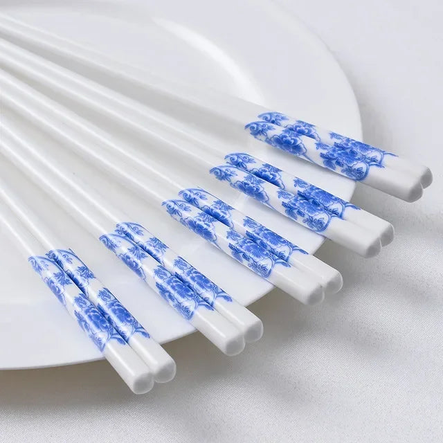 White kawaii chopsticks with blue patterns on a white plate